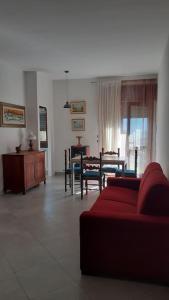 ein Wohnzimmer mit einem roten Sofa und einem Tisch in der Unterkunft lo Tsanty casa vacanza in Aosta