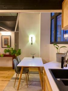 - une cuisine avec une table et des chaises dans la chambre dans l'établissement Loft moderne & cosy Terreaux / Croix Rousse - Courts et longs séjours, à Lyon
