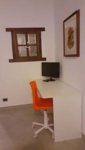 ein Büro mit einem Schreibtisch mit einem Computer und einem Stuhl in der Unterkunft lo Tsanty casa vacanza in Aosta