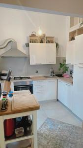 uma cozinha com armários brancos e um fogão em Apartment with spacious terrace Villa Floramy em Opatija