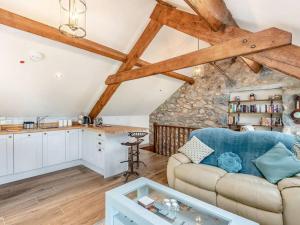 a living room with a couch and a kitchen at Pipistrelle Cottage a quirky gem near Snowdonia in Caernarfon