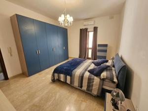 a bedroom with a bed and a blue cabinet at XL Seafront Home in Sliema in Sliema
