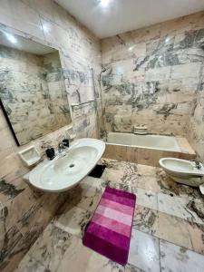 bagno con lavandino e tappeto viola sul pavimento di XL Seafront Home in Sliema a Sliema