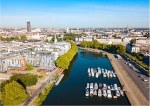 an aerial view of a city with boats in a river at La Cité des Coeurs LU Parking inclus in Nantes