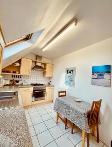 a kitchen with a table and a dining room at The Crows Nest in Eyemouth