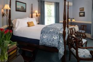 a bedroom with a bed and chairs and a window at Albemarle Inn - Asheville in Asheville