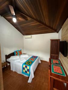 1 dormitorio con 2 camas y TV. en NayMar Paraty Casa Familiar, en Paraty