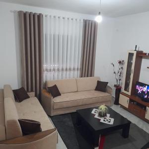 ein Wohnzimmer mit einem Sofa und einem Tisch in der Unterkunft Villa Besart in Berat
