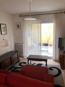 a living room with a red couch and a table at Big house with terrace in Paris in Paris