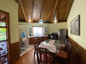 a kitchen with a glass table and wooden ceilings at Honduras Shores Plantations in Tela
