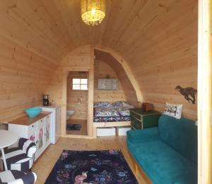 Habitación con sofá en una cabaña de madera en Tiny House Cuxhaven am See, en Nordholz