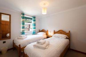 Dos camas en una habitación con toallas. en Tregurrian Villas, en Newquay