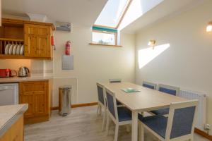 a kitchen and dining room with a table and chairs at Tregurrian Villas in Newquay