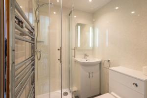 a bathroom with a shower and a sink and a toilet at Tregurrian Villas in Newquay
