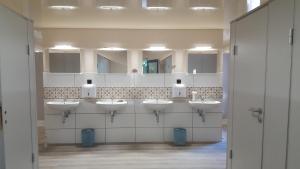 a bathroom with four sinks and a row of mirrors at Tiny House Cuxhaven am See in Nordholz