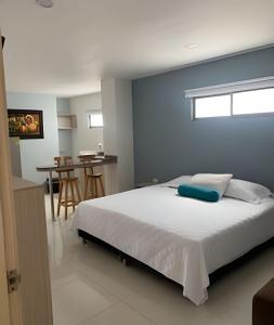 1 dormitorio con 1 cama grande y pared azul en Lagos Apartaestudios Apartamento, en Barranquilla