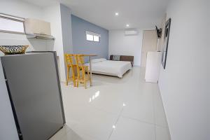 Habitación con cama, mesa y nevera. en Lagos Apartaestudios Apartamento, en Barranquilla