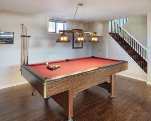 a red pool table in a room with a staircase at Home in Collingwood in Collingwood