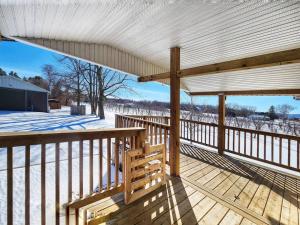 a wooden deck with a roof with snow on the ground at Home in Collingwood in Collingwood