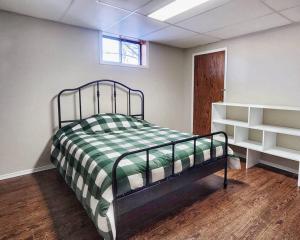 a bedroom with a bed with a green and white blanket at Home in Collingwood in Collingwood