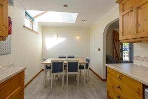 a kitchen with a table and chairs and a window at Tregurrian Villas in Newquay