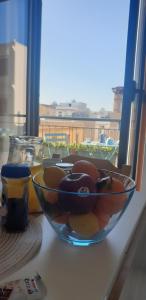 un bol de fruta sentado en una mesa junto a una ventana en RgB_Apartments en Lampedusa