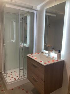 een badkamer met een douche, een wastafel en een bad bij La nuit glamour in Herblay
