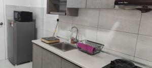 a kitchen counter with a sink and a refrigerator at The Robertson Bukit Bintang by Wowhome in Kuala Lumpur