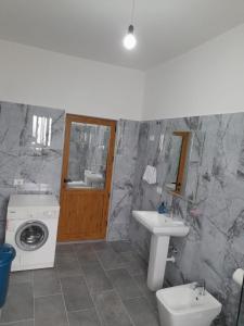 łazienka z umywalką i pralką w obiekcie Villa Besart w mieście Berat