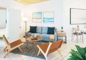ein Wohnzimmer mit einem Sofa, einem Tisch und Stühlen in der Unterkunft Island Oasis: Beach & Views in Enighed