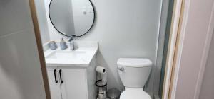 a bathroom with a white toilet and a mirror at Scarborough New 2-Bedroom Basement in Toronto