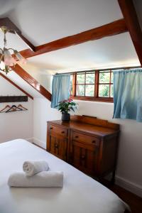 a bedroom with a bed with a dresser and a window at Ami Vine House in Cape Town