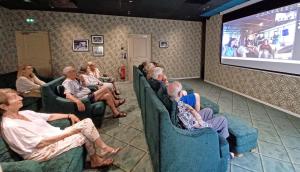 grupa ludzi siedzących w fotelach obserwujących ekran w obiekcie Casa Barbara Nice - Résidence Services w Nicei