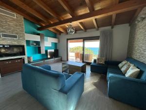 una sala de estar con muebles azules y vistas al océano. en DOLCE VITA holiday home, en Cala Gonone