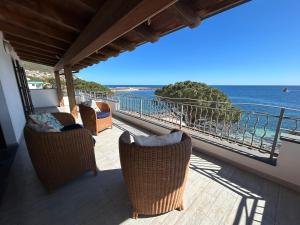 a balcony with chairs and a view of the ocean at DOLCE VITA holiday home in Cala Gonone