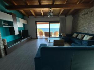 a living room with a blue couch and a view of the ocean at DOLCE VITA holiday home in Cala Gonone