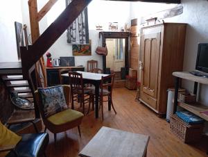 uma sala de estar com mesa e cadeiras e uma cozinha em La chapelle em Dinant