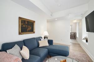 a living room with a blue couch and a table at Silverwood Serenity - Balcony and City Views with Parking in Philadelphia