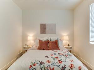 a white bedroom with a large bed with red pillows at Tranquil Locale Double Garage in American Fork