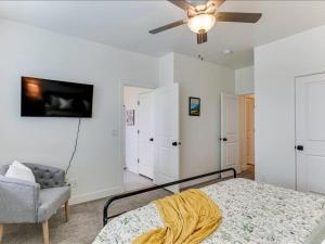 1 dormitorio con 1 cama, 1 silla y ventilador de techo en Tranquil Locale Double Garage, en American Fork