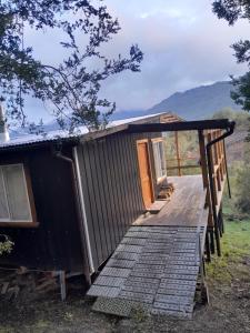 a wooden cabin with a ramp leading to the door at Cabaña Cacique Vista Hermosa in Cochamó