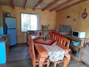 a kitchen and dining room with a table and chairs at Cabaña Cacique Vista Hermosa in Cochamó