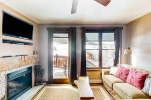 a living room with a couch and a fireplace at Village Hideaway in Copper Mountain