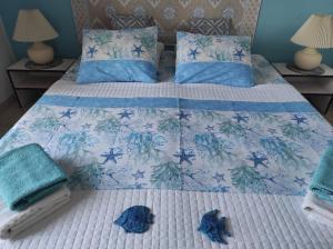 een bed met blauwe kussens en handdoeken erop bij Apartmán Panoramico in Costa Paradiso
