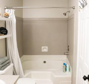 uma casa de banho com uma banheira branca e um chuveiro em Kids Parks Nearby Game Room King bed em Orem