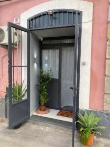 卡塔尼亞的住宿－The Guests Of G&G house，盆栽植物的房子的敞开的门