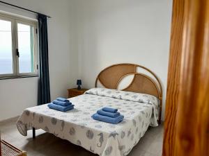 sypialnia z łóżkiem z niebieskimi ręcznikami w obiekcie Residence Araba Fenice Tropea w Tropei