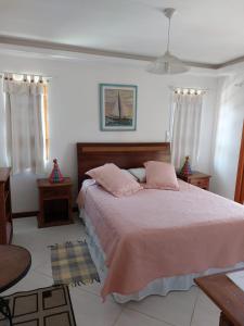 um quarto com uma cama grande e lençóis cor-de-rosa em Pousada Banzay em Paraty