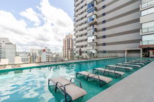 een zwembad met ligstoelen op een gebouw bij 360 VN Capote Valente by Housi in Sao Paulo