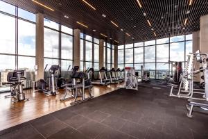 een fitnessruimte met loopbanden en stoelen in een kamer met ramen bij 360 VN Capote Valente by Housi in Sao Paulo